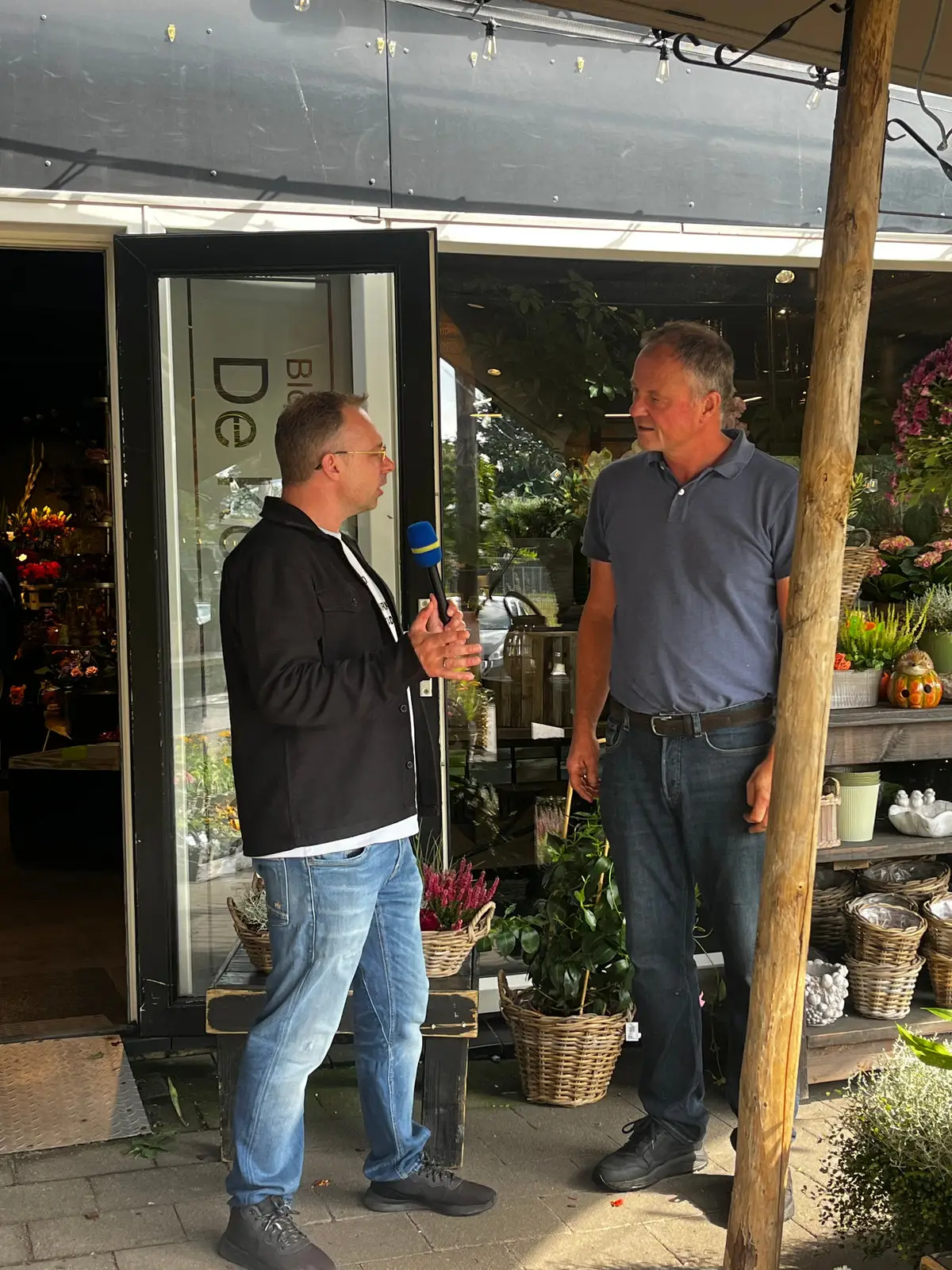 Matthijs Biesmans in gesprek bij Bloembinderij De Korenschoof, tussen bloemen en planten.
