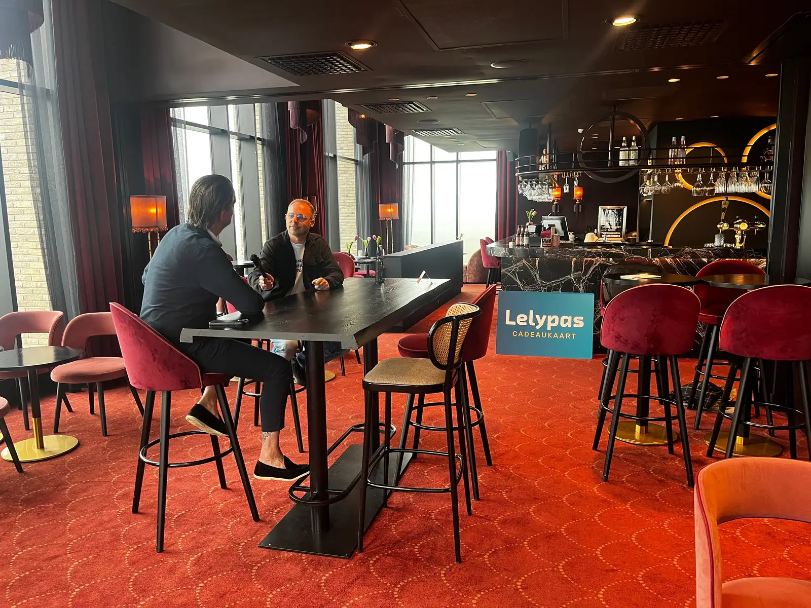 Interviewopname in Van der Valk Hotel Lelystad, met een Lelypas-bord bij de bar.